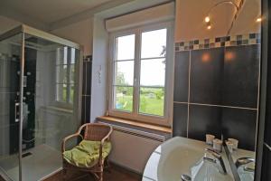 GlandonLe gueraudier的带淋浴和盥洗盆的浴室以及窗户。