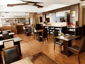 巴库Smith's Boutique Hotel的一间带桌椅的餐厅和一间酒吧
