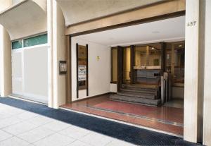 巴勒莫巴勒莫中心美居酒店的进入带玻璃门和楼梯的大楼
