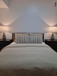 宿务Casa de Rosand的一间卧室配有一张床、两个床头柜和两盏灯。