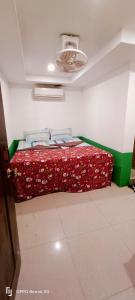 瓜隆岛Family Guesthouse的一间卧室配有一张带红色毯子的床