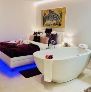 Gebenstorfperfect lifestyle Design Boutique & Private SPA的配有床铺的客房内的白色浴缸