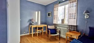 VindelnKronlund Kursgård的配有桌椅和蓝色墙壁的客房