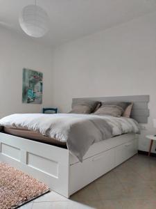 圣佩莱格里诺温泉MANZONI APARTS - SUITE Superior的卧室内的白色床,设有白色的墙壁