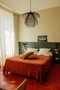 格吕桑La Maison de Gruissan的卧室配有一张带橙色床单和枕头的大床。