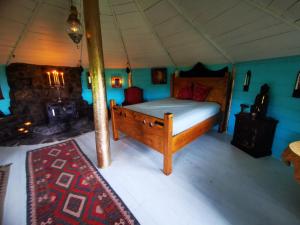 牛顿斯图尔特The Round House的帐篷内一间卧室,配有一张木床
