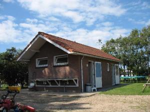 阿赫特克克Trekkershuisje 't Zeeuws Knoopje的一座带屋顶的小砖屋