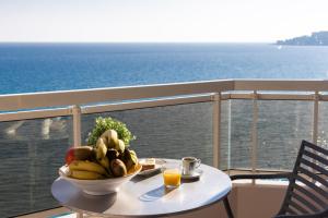 芒通里瓦艺术温泉酒店的阳台上的桌子上放着一碗水果