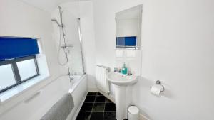 斯塔福德Cross Court, Stafford by BELL Apartments的白色的浴室设有水槽和淋浴。
