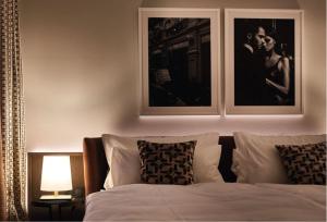汉堡Clounys Hotel的卧室配有一张墙上有两张照片的床。