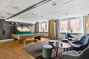 斯德哥尔摩康姆贝斯特韦斯特酒店的台球室配有台球桌和椅子