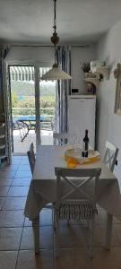 科尔丘拉Beach house Nada的厨房配有白色桌子和一瓶葡萄酒