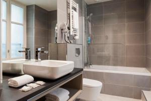 巴黎提姆蒙马特尔酒店的一间带水槽、浴缸和卫生间的浴室