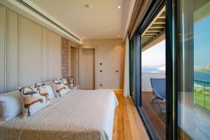 京多安Mare Deluxe Residences & Villas的一间卧室设有一张大床和一个大窗户