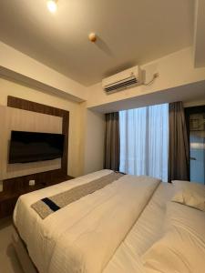巴淡岛中心Meisterstadt Pollux Habibie Apartment by uhomeid的卧室设有一张白色大床和一扇窗户。