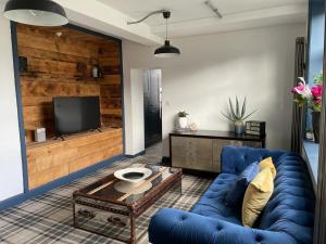 利兹The Beulah Apartments的客厅配有蓝色的沙发和电视