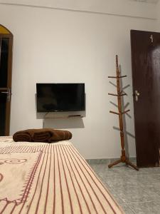 卡舒埃拉斯迪马卡库Pousada Boa Vista的一间卧室配有一张床,墙上配有电视