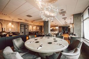 塔博尔派勒萨特酒店的一间带桌椅和吊灯的用餐室