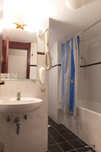 扎雷克MC Hotel的浴室配有盥洗盆、镜子和浴缸
