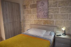 维多利亚St George of Lydda B&B的一间卧室设有一张床和砖墙
