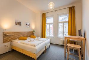 布拉格Self-service Hotel Ostaš Praha的一间卧室设有两张床、一张桌子和一个窗口。