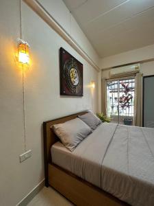 Ban Khlong Nong Yai66 Apartment的卧室配有一张挂在墙上的带时钟的床