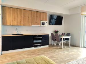 坦佩雷Fully Equipped New Apartment With Free Parking的厨房配有黑色橱柜和桌椅