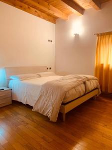 维琴察Albergo Torre的一间卧室设有一张大床,铺有木地板