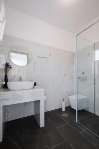 阿里拉斯Diamond Arillas Luxury Apartments的白色的浴室设有水槽和淋浴。