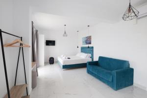 阿里拉斯Diamond Arillas Luxury Apartments的客厅配有蓝色椅子和一张床