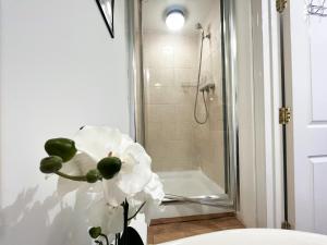 KentLovely 1 Bedroom Flat In Gravesend的浴室内花瓶中的白色花朵