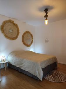 MiersAu Grand Bonheur - Gîte Padirac - Rocamadour的卧室配有一张床,墙上有两个篮子