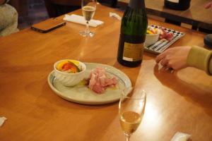 Shibetsuゲストハウス＆カフェバー　エストアール的一张桌子,上面放着一盘食物和一瓶葡萄酒