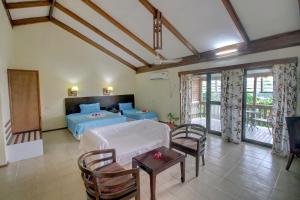 霍尼亚拉Honiara Hotel的卧室配有一张床和一张桌子及椅子