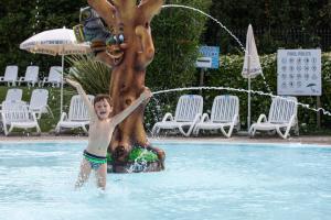 圣费利切德尔贝纳科Campeggio Europa Silvella的喷泉旁游泳池里的男孩