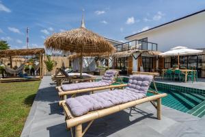 高兰Manao Seaview Pool Villa 24 - 5 Mins Walk To The Beach的一组休息室和遮阳伞,位于游泳池旁