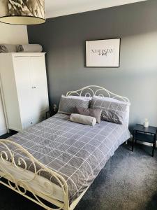 克利索普斯2 bedroomed house close to Cleethorpes seafront的卧室内的一张床位,卧室内有灰色的墙壁