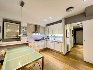 巴塞罗那ArtlifeBCN Urban Oasis Apartment的厨房配有白色橱柜和餐桌