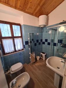 马西亚娜马里纳Villa Le Sprizze a bordo del mare - Goelba的蓝色瓷砖浴室设有水槽和卫生间