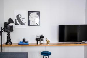 希俄斯Kaleo Chios Luxury Apartments的客厅配有木架上的电视
