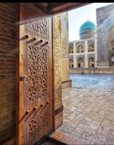 布哈拉KAMIR Guest House的一座有清真寺背景的敞开的门