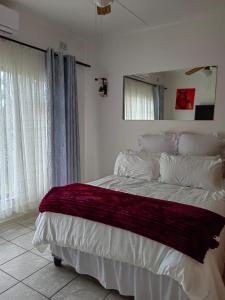 马盖特Msongi Guest House的一间卧室配有一张床铺,床上铺有红色毯子