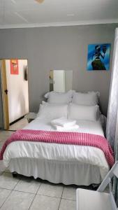 马盖特Msongi Guest House的一间卧室配有一张带白色床单的大床