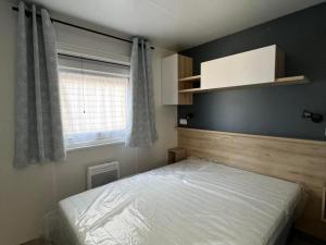 圣让-德蒙Superbe Mobil home 6-8 personnes (57)的一间小卧室,配有床和窗户
