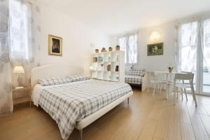 里乔内B&B Cá Bianca Ventisette Riccione的白色卧室配有床和桌椅