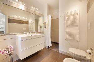 里乔内B&B Cá Bianca Ventisette Riccione的一间带水槽、卫生间和镜子的浴室