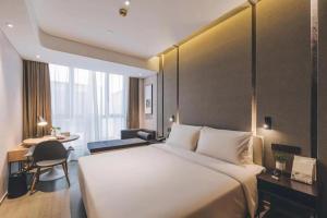 Fengbang上海嘉定江桥嘉怡路地铁站亚朵酒店的酒店客房设有一张大床和一张书桌。