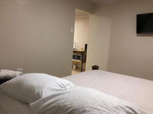 Santiago EsteRivera Family Apartments的卧室配有白色的床和电视。