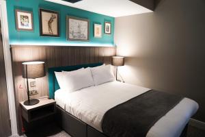 泰恩河畔纽卡斯尔Great North Hotel的一间卧室配有一张蓝色墙壁的床