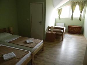 KopačevoB&B Majhen的客房设有两张床、一把椅子和窗户。
